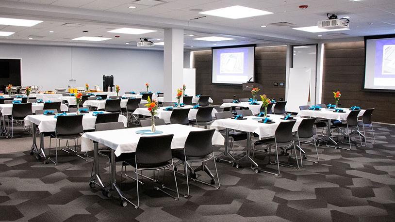 large conference room with projector and dining tables for event